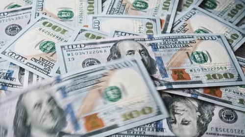 100-Dollar-Scheine fallen auf einen rotierenden Dollarstapel. Nahaufnahme
