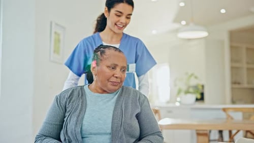 Woman in Wheelchair Receives Assistance from a Nurse