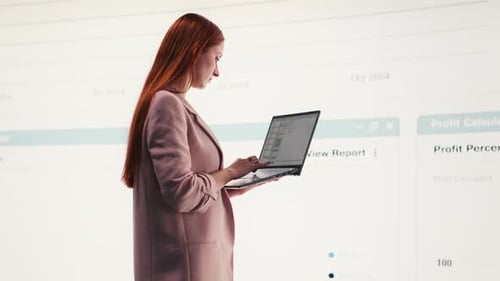 Comparing Profit Data Laptop and Businesswoman Using Charts
