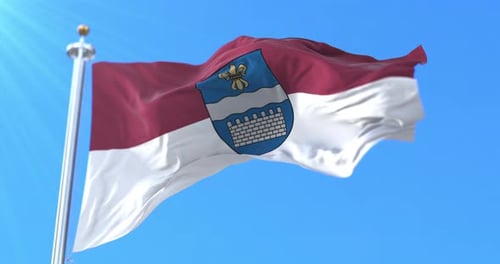 Realistic Waving Flag with Emblem Against Clear Blue Sky