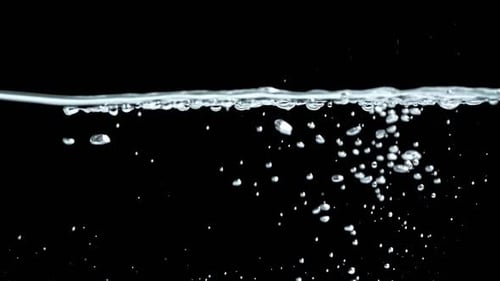 Liquid Being Poured in Water Creating Bubbles