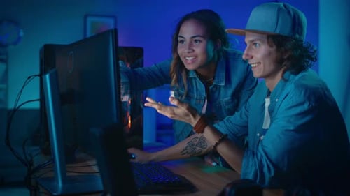 Couple Working Together at Computer in Dark Room