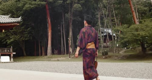 Slide shot of a person walking towards an old temple in Kyoto, Japan 4K slow motion