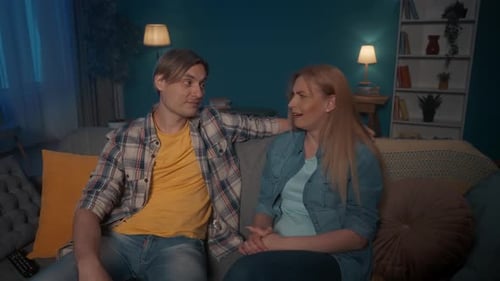 Couple Laughing Together on Couch at Home