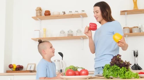 Mom and Little Son in Blue Tshirts are Having Fun in the Kitchen While Cooking