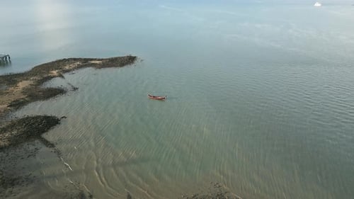 Aerial View of a Motorboat Exploring a Tropical Bay with Clear Waters