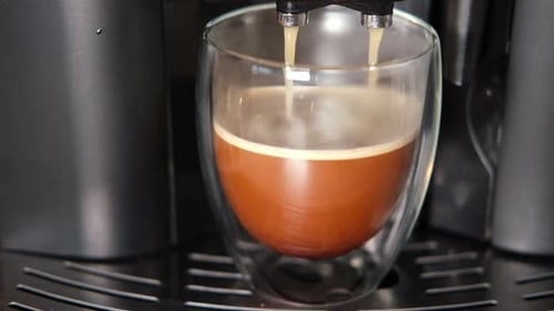 Coffee Pouring into Glass Cup from Machine