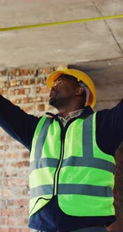 Measuring, black man and construction worker on site for renovation, maintenance or building