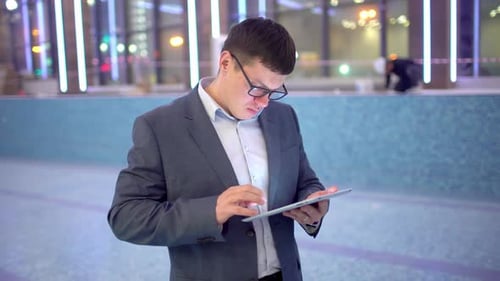 Businessman Man Architect Using Tablet Night Standing By Window in Spa Sport Office at Night