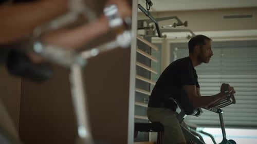 A Man is Doing Various Indoor Exercises with Different Fitness Equipment to Boost His Health