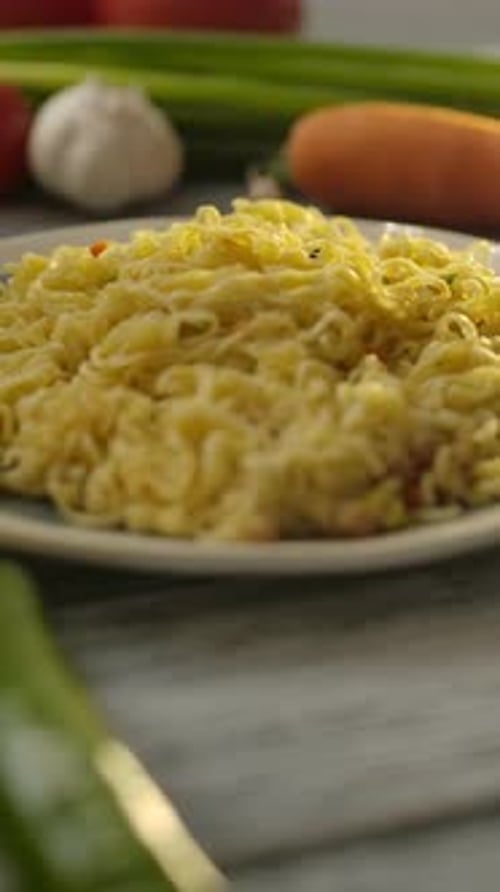 Noodles with fresh vegetables on the kitchen table