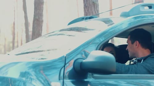 Young Man and Woman Riding Together in Car in Forest Happy Positive Cheerful Couple Sit and Look at