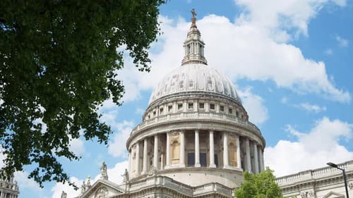 The Dome of St. Paul's Cathedral rising above the trees with a clear blue sky in the background in L