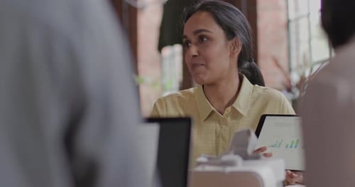 Adult Woman Presenting Business Data on Tablet