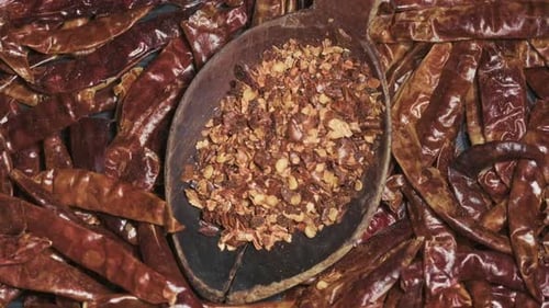 Red Chili Pepper Flakes in Wooden Board Top View