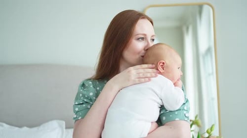 Loving Mother Holding Adorable Infant Indoors