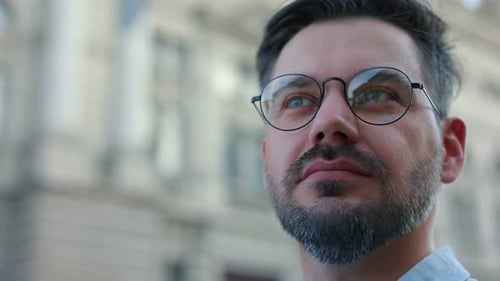 Portrait of Handsome Businessman Wearing Glasses Standing at the Street and Looking Away in Front of