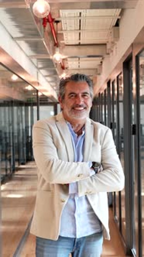Mature Businessman Smiling Confidently in a Modern Office Hallway