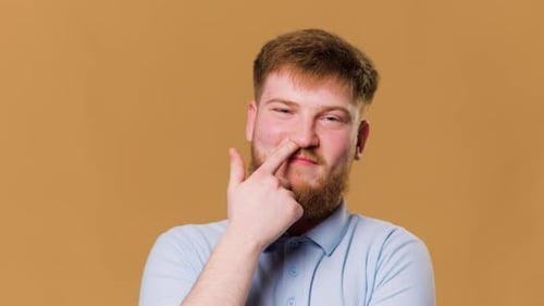 A Comic Image of a Teenager with a Crazy Expression and Finger in Nose in a Studio Shot