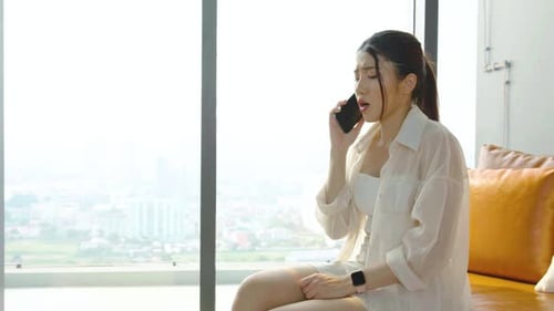 Distressed Woman Receives Bad News on Phone in Apartment