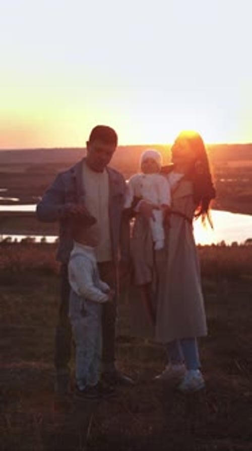Family Enjoying a Beautiful Green Landscape at Sunset