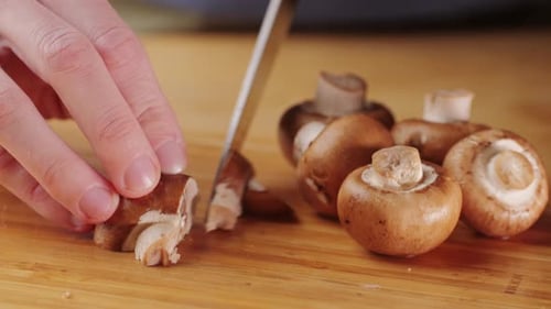 Chef Cutting the Mushrooms on a Wooden Board with Knife Mushroom Cooking Close Up