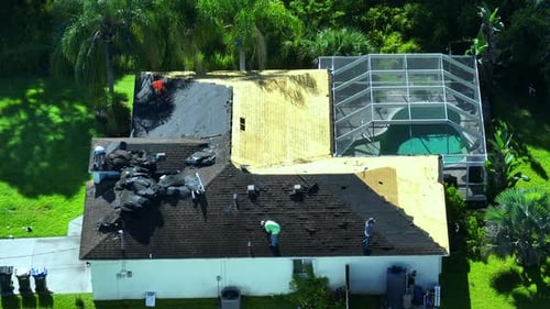 Construction Workers Removing Old Asphalt Shingles on Residential Private House Roof Rooftop Repair
