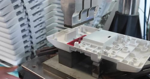 Travailleur plaçant un produit en plastique dans un A pour le soudage par ultrasons - gros plan, 4K