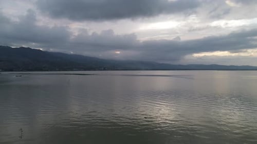 Aerial view over the water of the lake with sunset views and sun reflections. Aerial view of lake.