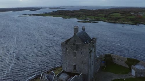 Cinematic aerial capturing Dunguaire Castle in Galway, revealing the scenic beauty of Kinvara Bay an