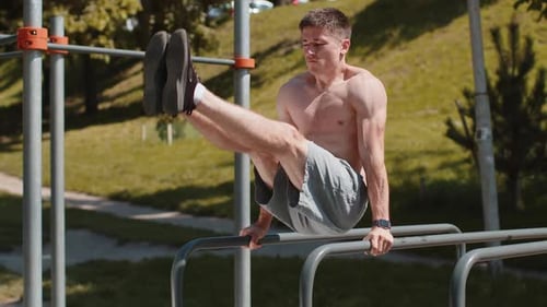 Man Exercising on Parallel Bars in Park