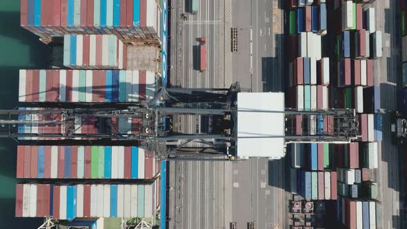 Truck driving in a lane under the gantry cranes while loading a giant ...