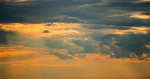 Golden Sunlight Streaming Through Clouds at Sunrise