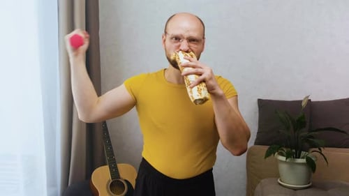 Man Lifts Weights and Eats Wrap in Living Room
