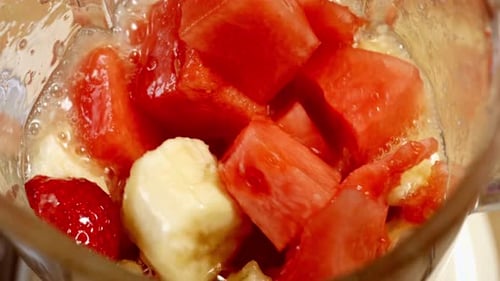 Fresh Watermelon Strawberry and Banana Pieces Blending into a Smoothie