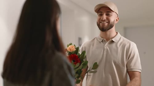 Man delivers flowers and gift to smiling woman