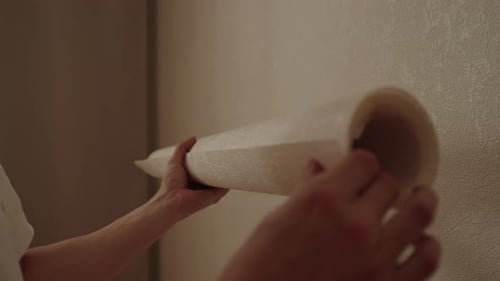 Hands Unrolling Wallpaper Indoors