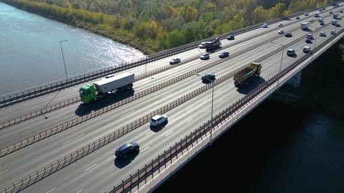 Aerial view of road bridge highway across the river in city area. Lorry is driving on the bridge. Sk