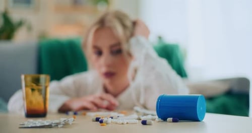 Woman with Pills and Medicine on Table