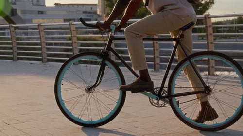 Afroamerikaner mit Rucksack fängt am frühen Morgen mit dem Fahrradfahren an