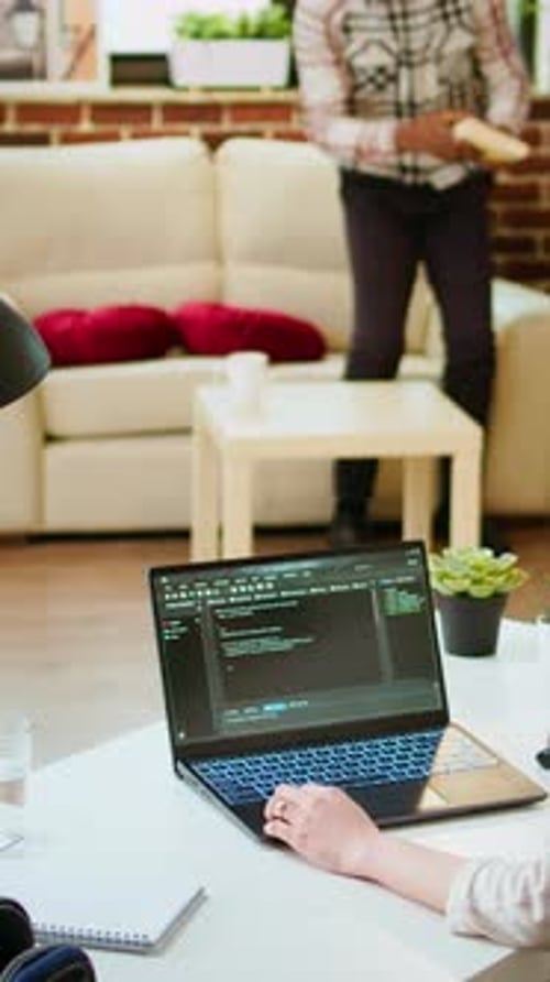 Vertical Video Software Developer Types Programming Code in a Cozy Home Office Setup