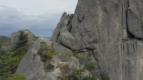 Vue aérienne en pivot autour d'une énorme pierre mégalithique ancienne posée au bord d'une falaise rocheuse o