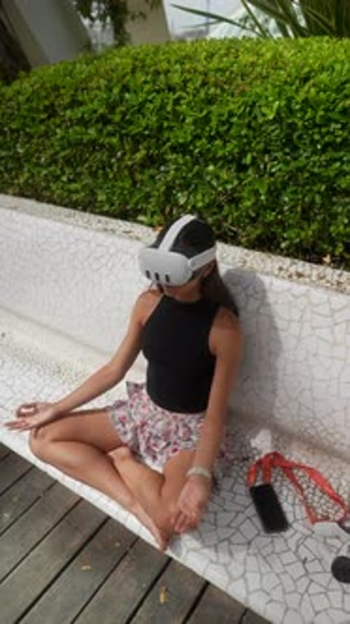A Woman is Peacefully Meditating Outdoors in a Park While Immersed in a Virtual Reality Experience
