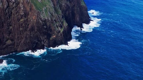 Vertiginous Rock Faces Tower Over Churning Wild Ocean Currents