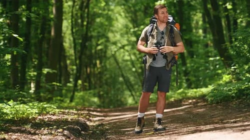 Orientação na floresta. Homem ativo, turista com mochila, se perdeu durante uma caminhada na floresta