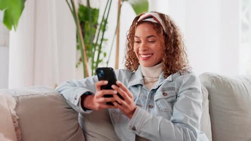 Woman Relaxing on Couch Using Smartphone