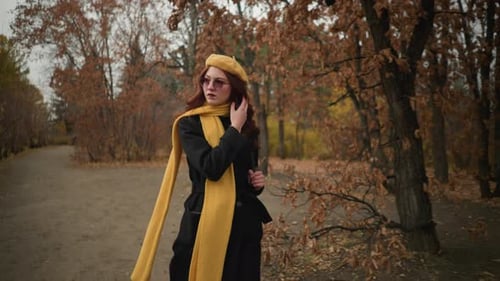 Focused Tourist in Yellow Adjusting Hair on Forest Walk