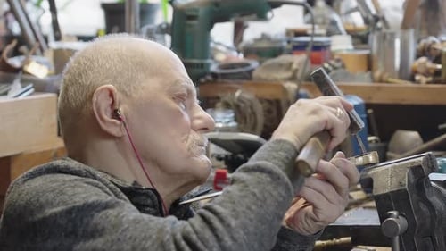 Senior Elderly Master Jeweler in Wheelchair Works in a Workshop
