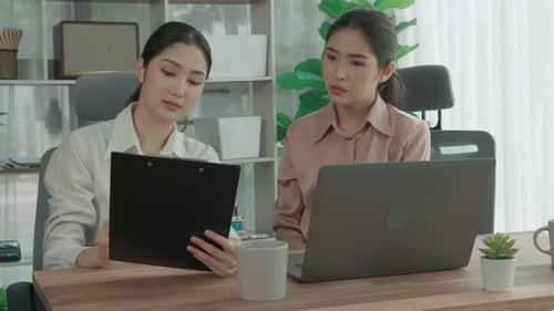Two Young Enthusiastic Businesswoman Working Together in the Office Workspace