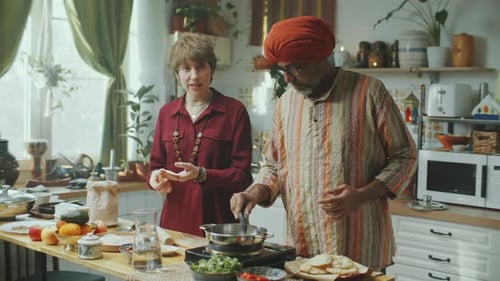 Two People Cooking Food Together in Bright Kitchen